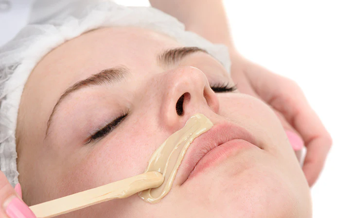 a woman with a wax on her face