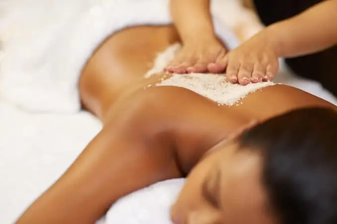 a woman receiving a body scrub