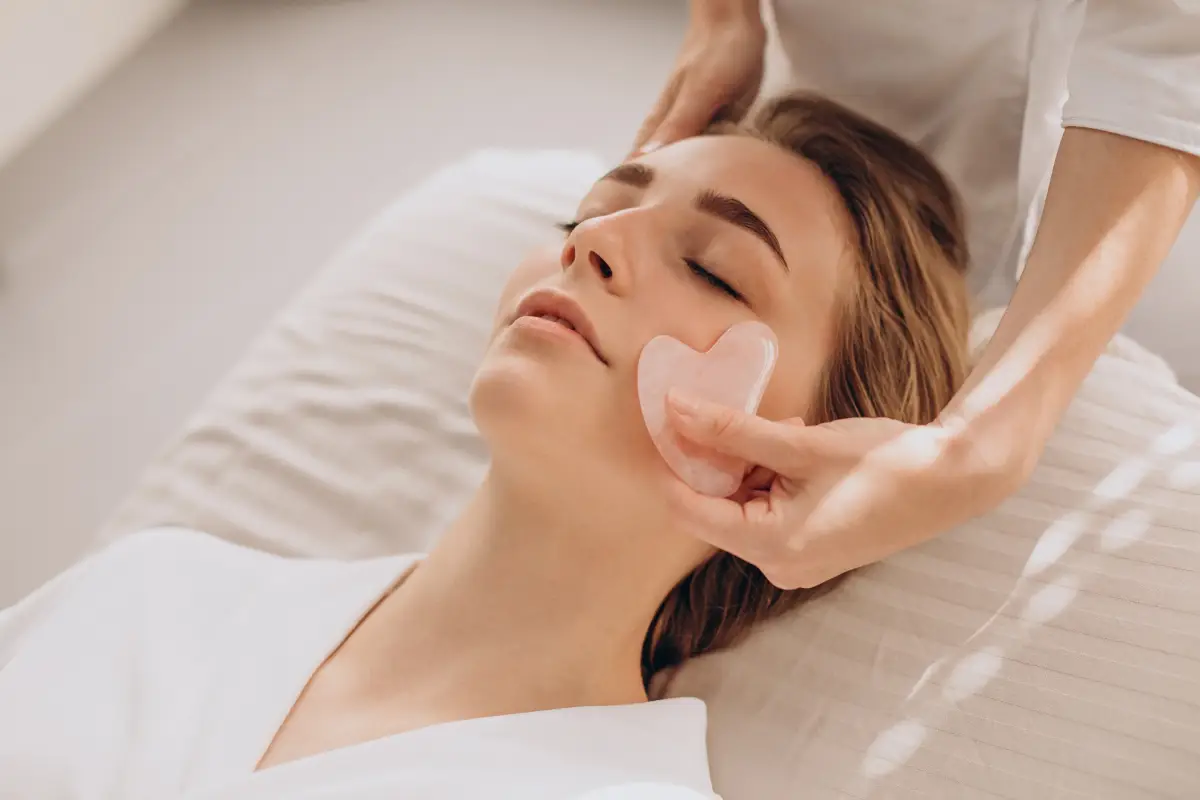 a woman lying down with her eyes closed and a pink heart on her face