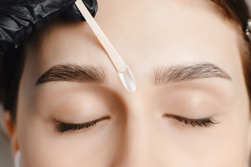 a person getting a wax on their eyebrows