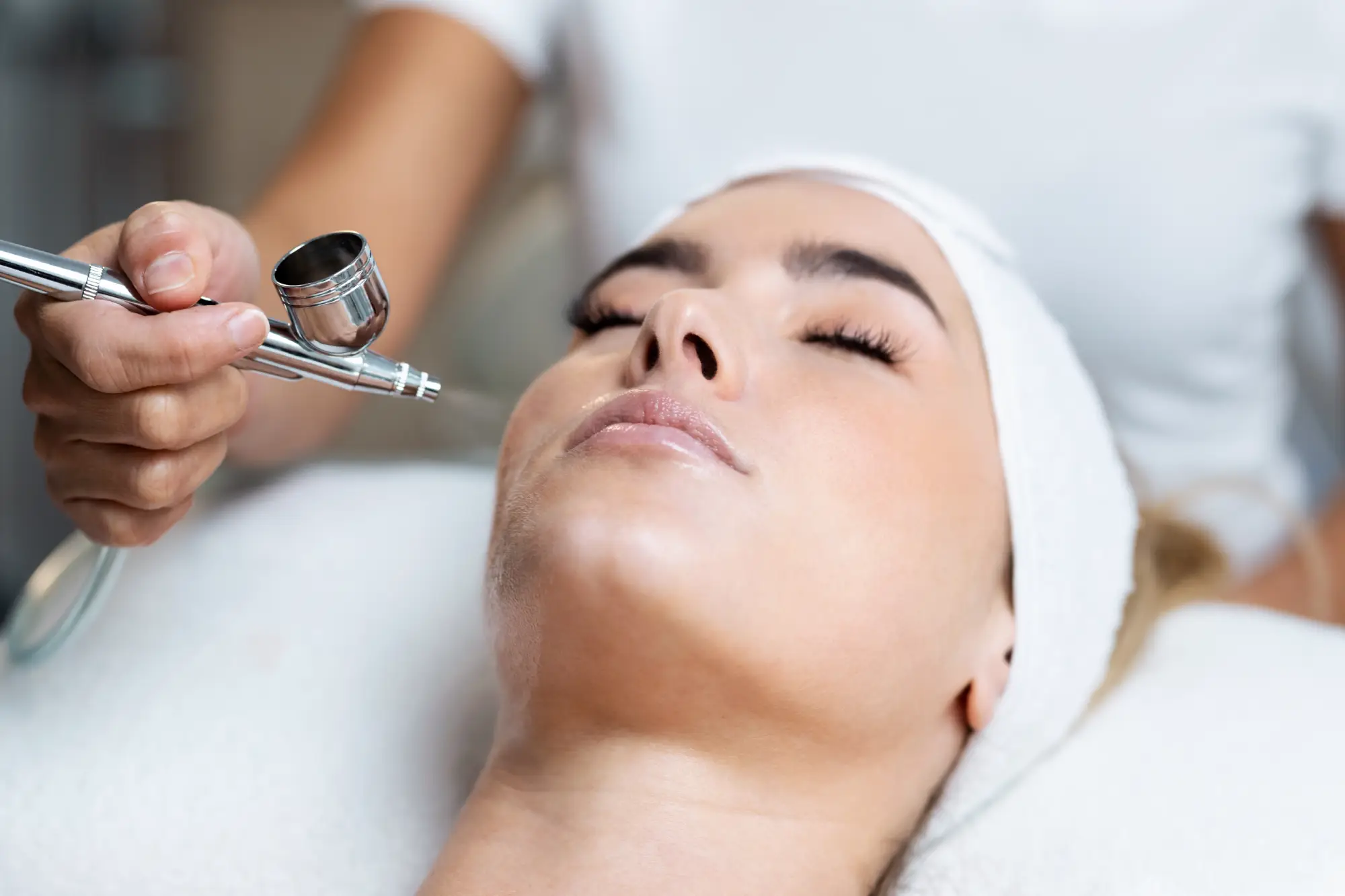 a person using a tool to apply a face treatment